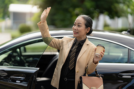 中老年群体摄影照片_亚洲高级女商人的肖像在上班时走出豪华车。