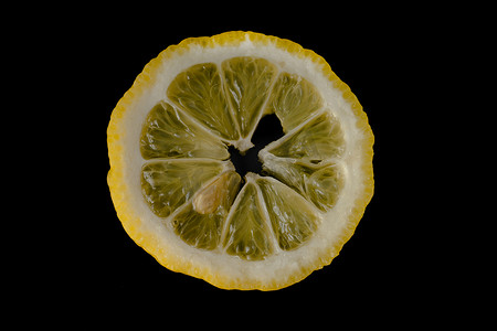 上半圆半圆摄影照片_五片柠檬片在黑色背景上排成半圆，隔离