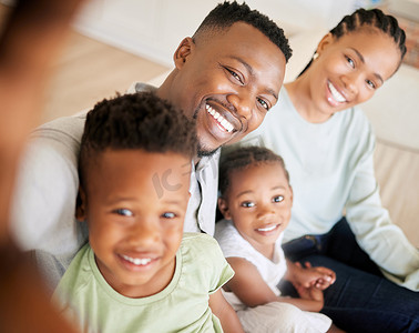 一个年轻微笑的非洲裔美国家庭坐在客厅里自拍的肖像。