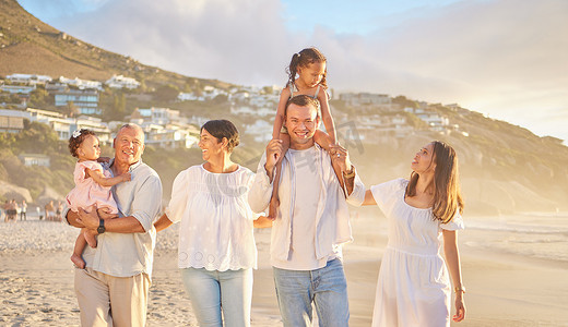 快乐的混合种族六口之家在海滩上散步。