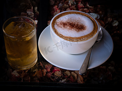 拿铁咖啡摄影照片_自然背景下的白杯卡布奇诺拿铁咖啡的顶视图。