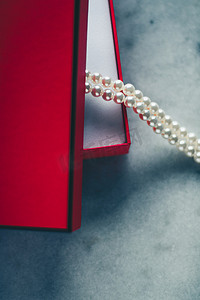 红色礼品盒中的精美珍珠，奢华礼物 - 适合她风格概念的珠宝和奢华礼物