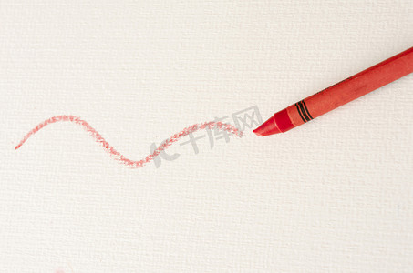 红色蜡笔在白纸上绘制波浪线
