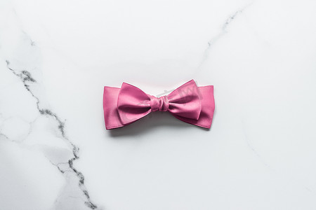 大理石背景上的粉色丝带和蝴蝶结、女婴送礼会礼物和豪华美容品牌的魅力时尚礼品装饰、假日平铺设计