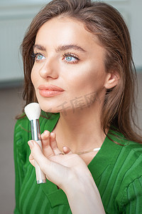 粉底液时钟摄影照片_化妆师应用色调粉底的专业化妆