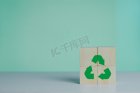 带有回收图标和绿色工业的木制立方体。