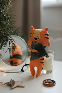2022虎年背景摄影照片_可爱的毛绒玩具老虎，装饰有舒适的圣诞节或新年背景。 
