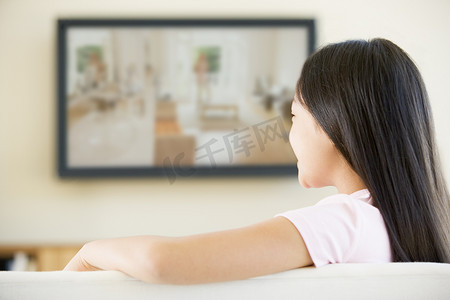 平面客厅摄影照片_客厅里的年轻女孩配有平面电视