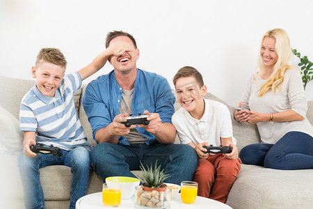 快乐的年轻家庭在电视上玩电子游戏。