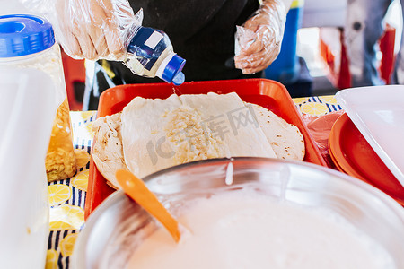 用腌洋葱制作传统玉米饼的手的特写。