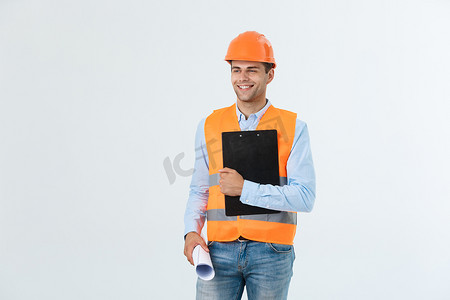年轻微笑英俊的建筑师工程师的半身肖像，戴着橙色头盔，摆着蓝图，看着白色背景中隔离的相机，复制空间