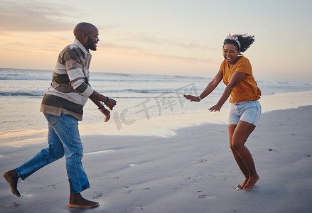 爱、自由和情侣在日落时分的海滩上，在大自然中欢笑并享受暑假的乐趣。