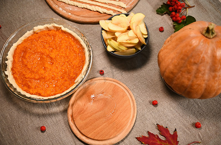 烤南瓜摄影照片_质朴的静物画，配有感恩节节日南瓜派和苹果的配料。