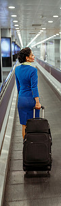 携带旅行袋在机场的女空乘人员