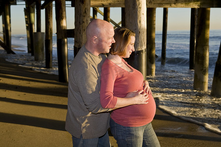 橘子摄影照片_看日落的怀孕夫妇