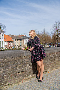 4.23摄影照片_比利时布鲁日 — 2022 年 4 月 23 日，拿着鲜花的女孩。