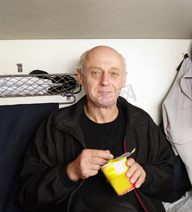 大型客运车摄影照片_客运列车车内吃快餐的男子
