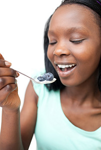 吃蓝莓摄影照片_吃蓝莓酸奶的非裔美国妇女