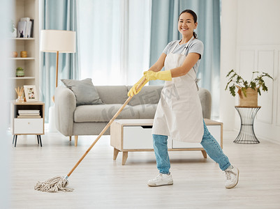 亚洲清洁工妇女在房屋或家里的休息室或客厅地板上拖地和清洁污垢和灰尘。