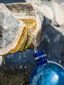 用公共来源的新鲜泉水填充塑料瓶