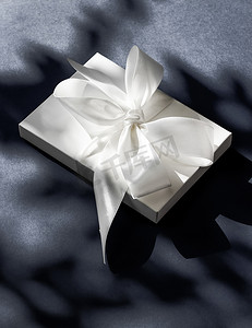 黑色背景上带丝带和蝴蝶结的豪华假日白色礼盒、豪华婚礼或生日礼物