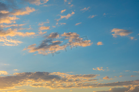 美丽的夕阳天空与蓝色背景上的彩云