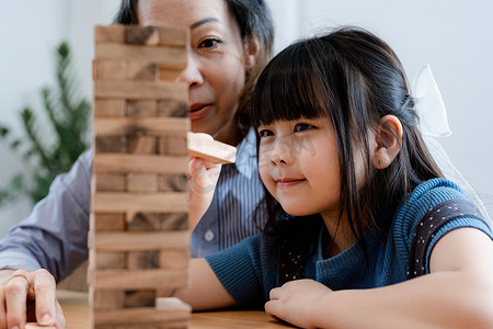 亚洲肖像、孙子孙女奶奶奶奶和孙女高兴地参加块木游戏拼图活动并提高孙子们的技能