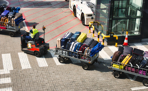 2019年8月4日 — 英国伦敦：在机场跑道上运送行李的机动行李车