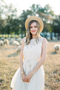 戴草帽的女孩站在草坪上