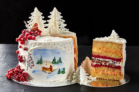 彩绘森林摄影照片_冬天的蛋糕上覆盖着白色的糖霜，森林里有彩绘的房子，树木和红罗文。
