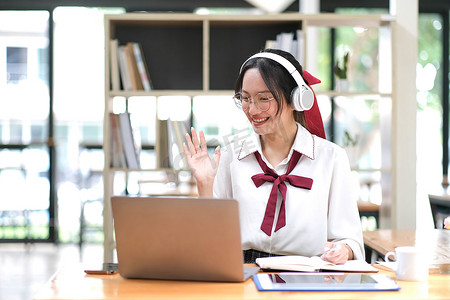 亚洲女学生在线学习班学习在线视频通话变焦老师，快乐的亚洲女孩用电脑笔记本电脑在线学习英语。