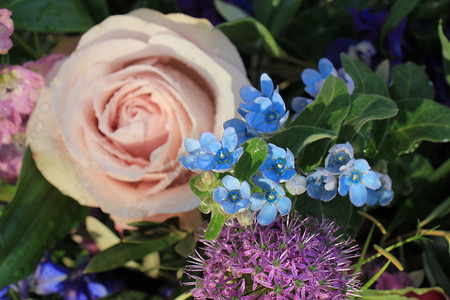 花卉婚礼装饰中的大紫色玫瑰，配有蓝色和紫色的小花