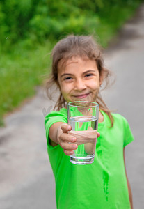 小女孩喝水摄影照片_小女孩从玻璃杯里喝水。