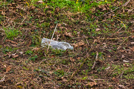 矿泉水瓶摄影照片_一个塑料矿泉水瓶被扔掉，在大自然中慢慢腐烂