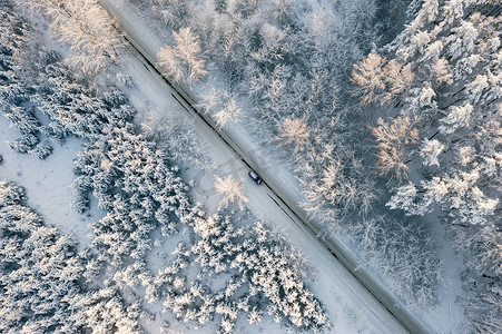 冬天阳光摄影照片_汽车在冬季柏油路上行驶，空中顶视图