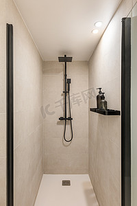 现代淋浴区配有黑色雨淋头和手持式淋浴。