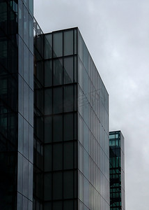 英国伦敦 — 2006年10月22日：玻璃和钢制办公室的矩形窗户（由福斯特和合作伙伴设计的“更多伦敦庄园”）背景阴云密布。