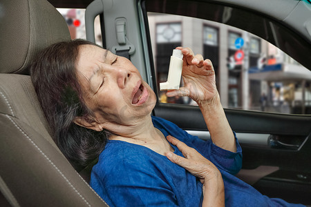 老妇在路上拿着哮喘喷雾在车内窒息