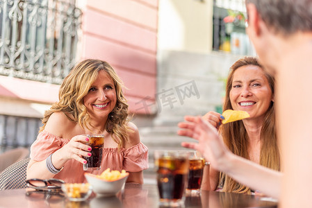 五个人摄影照片_中年成年女性在与朋友聊天时拿着饮料