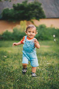 性格开朗摄影照片_性格开朗、活泼的幼儿男孩带着微笑和幸福跑到镜头前。