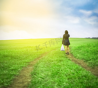 行走的女人摄影照片_提着购物袋在田野里行走的女人，在田野路上行走的女人