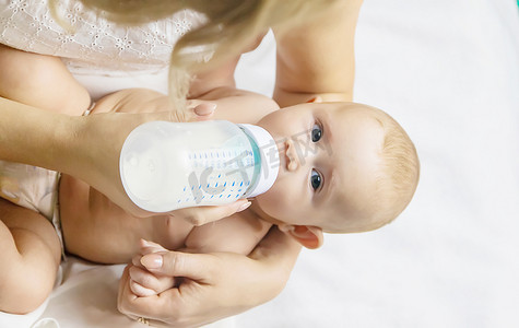 妈妈用奶瓶给宝宝喂奶。
