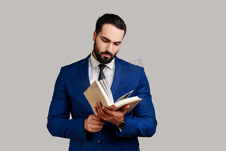 专心致志地留着胡子的男人读书，享受阅读，站着专注于激动人心的情节。
