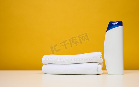用于凝胶和洗发水的白色塑料瓶和扭曲的白色毛圈毛巾