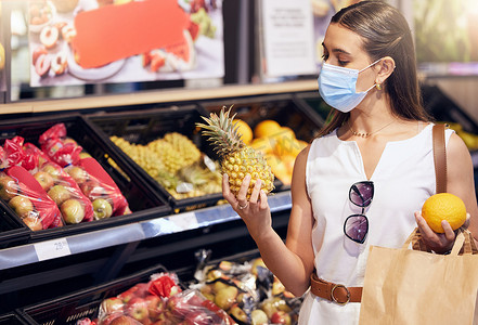妇女在超市购物时戴着口罩以预防新冠病毒。