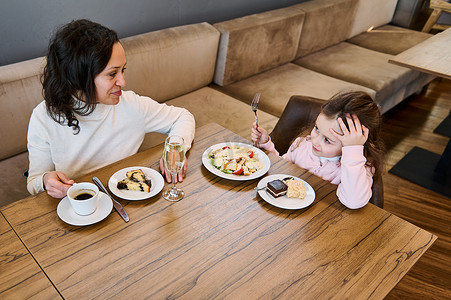 幸福慈爱的母亲和她可爱的女儿的头像 — 可爱的小女孩在自助餐厅一起吃早餐