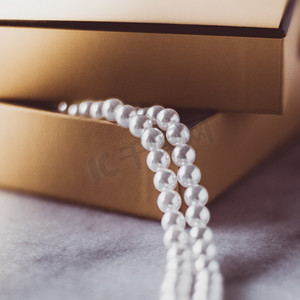 珍珠首饰摄影照片_金色礼品盒中的珍珠首饰