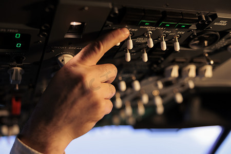 飞机空中摄影照片_航空飞行员使用驾驶舱内的控制面板来驾驶空中飞机