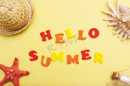 summer背景摄影照片_黄色背景上的“Hello Summer”字样，上面有贝壳、帽子、海星。