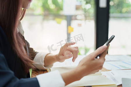 亚洲女商人摄影照片_亚洲女商人使用电话联系商业伙伴